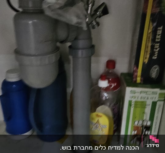 צנרת מתחת לכיור עם מחברים וברזים